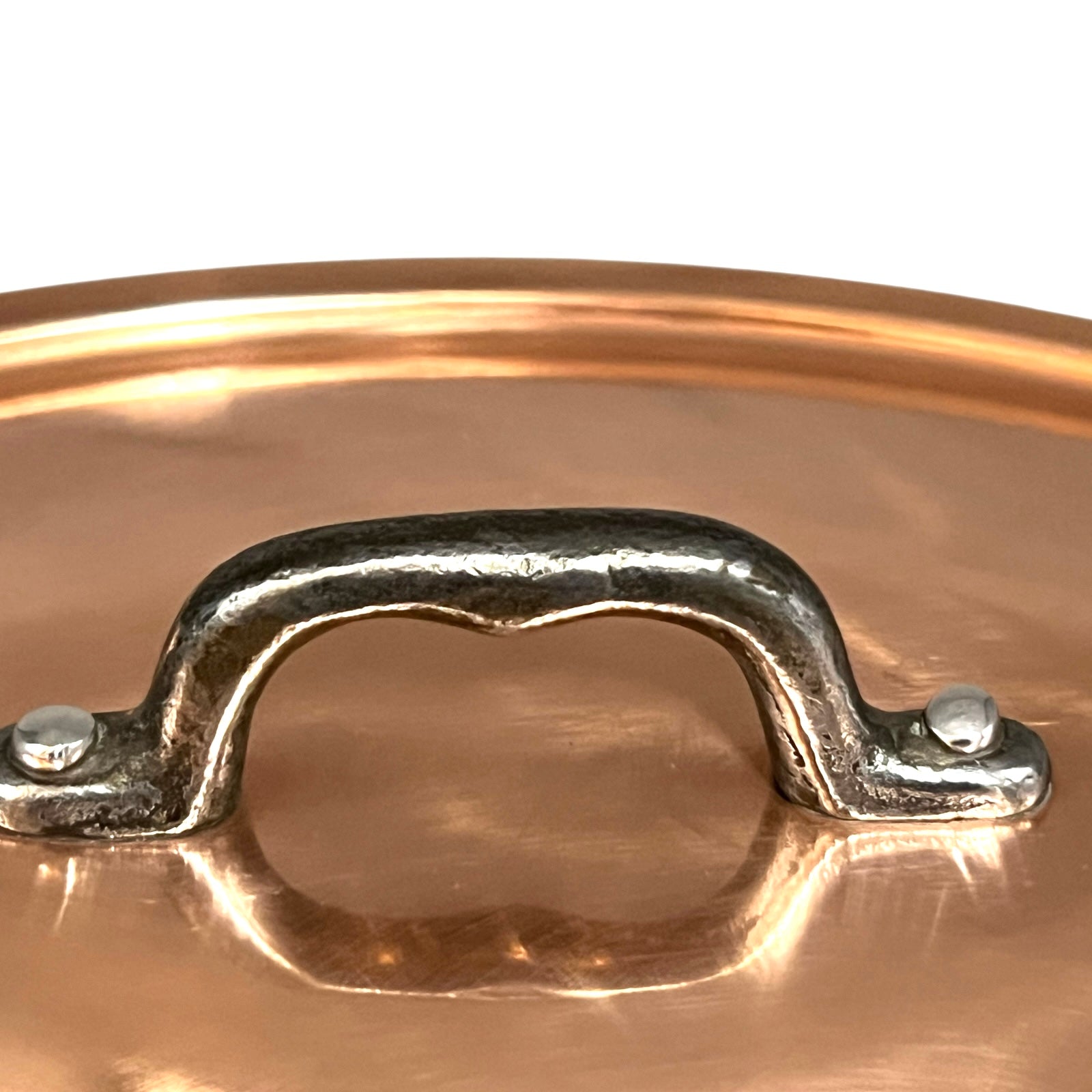 Close-up of a copper pot handle on a white background