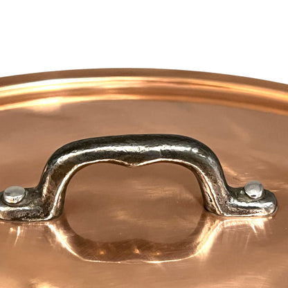 Close-up of a copper pot handle on a white background