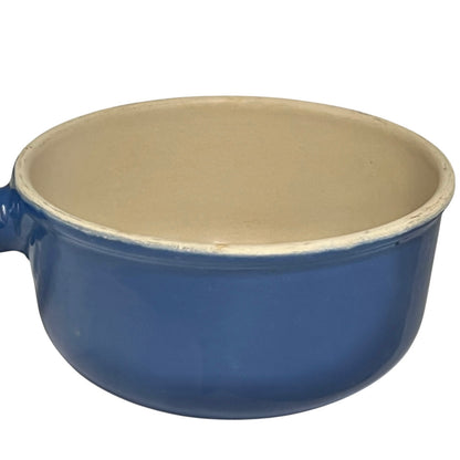 Blue Le Creuset pan with beige interior on a white background
