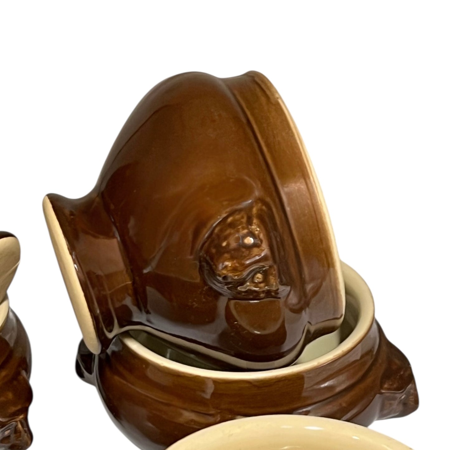 Brown ceramic bowl with decorative handles on a white background