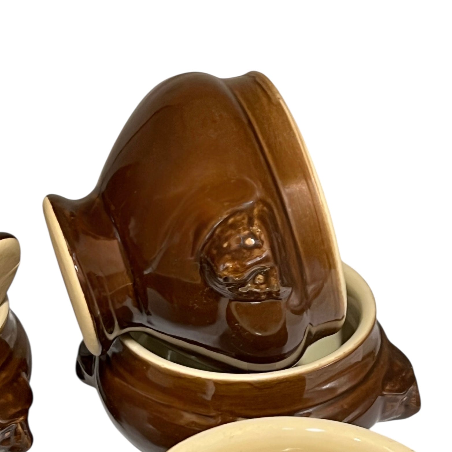 Brown ceramic bowl with decorative handles on a white background