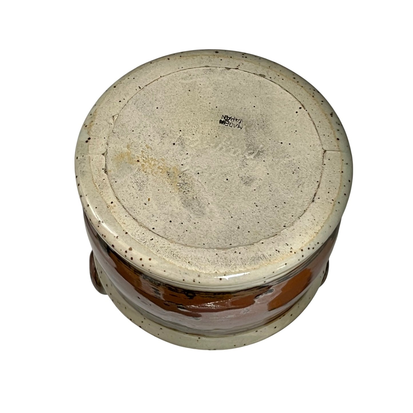 Round stone-like object with a textured surface on a white background