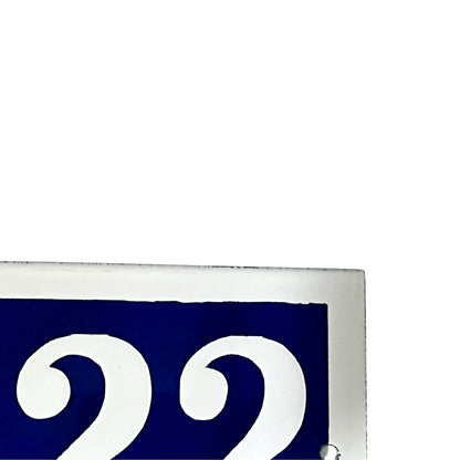 Blue sign with white number '22' on a white background