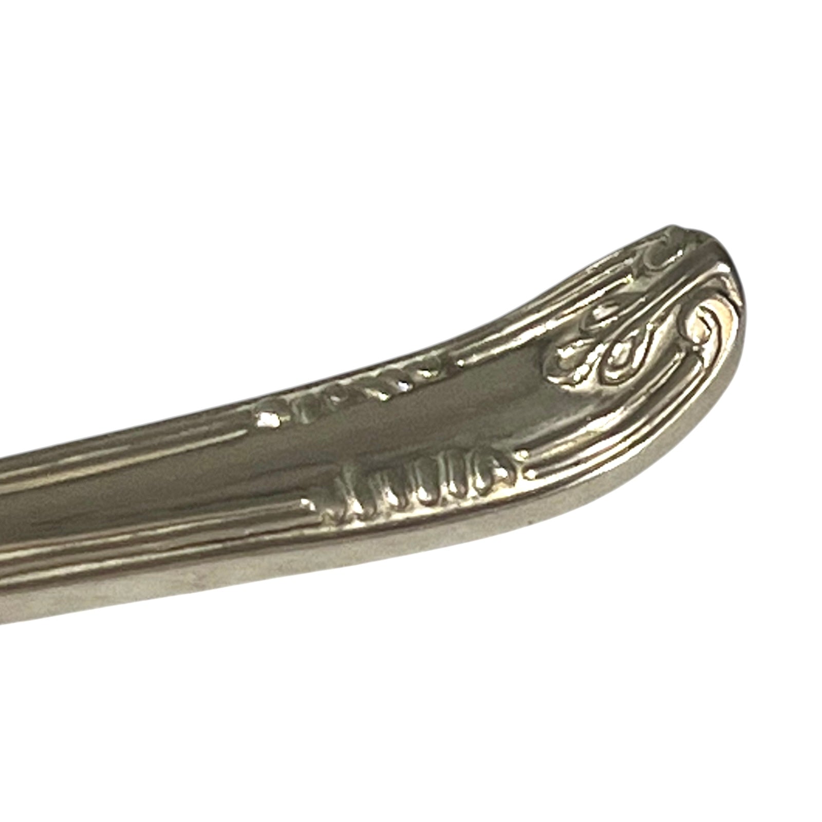 close up of a decorative Christmas tree shaped silver candle snuffer on a white background