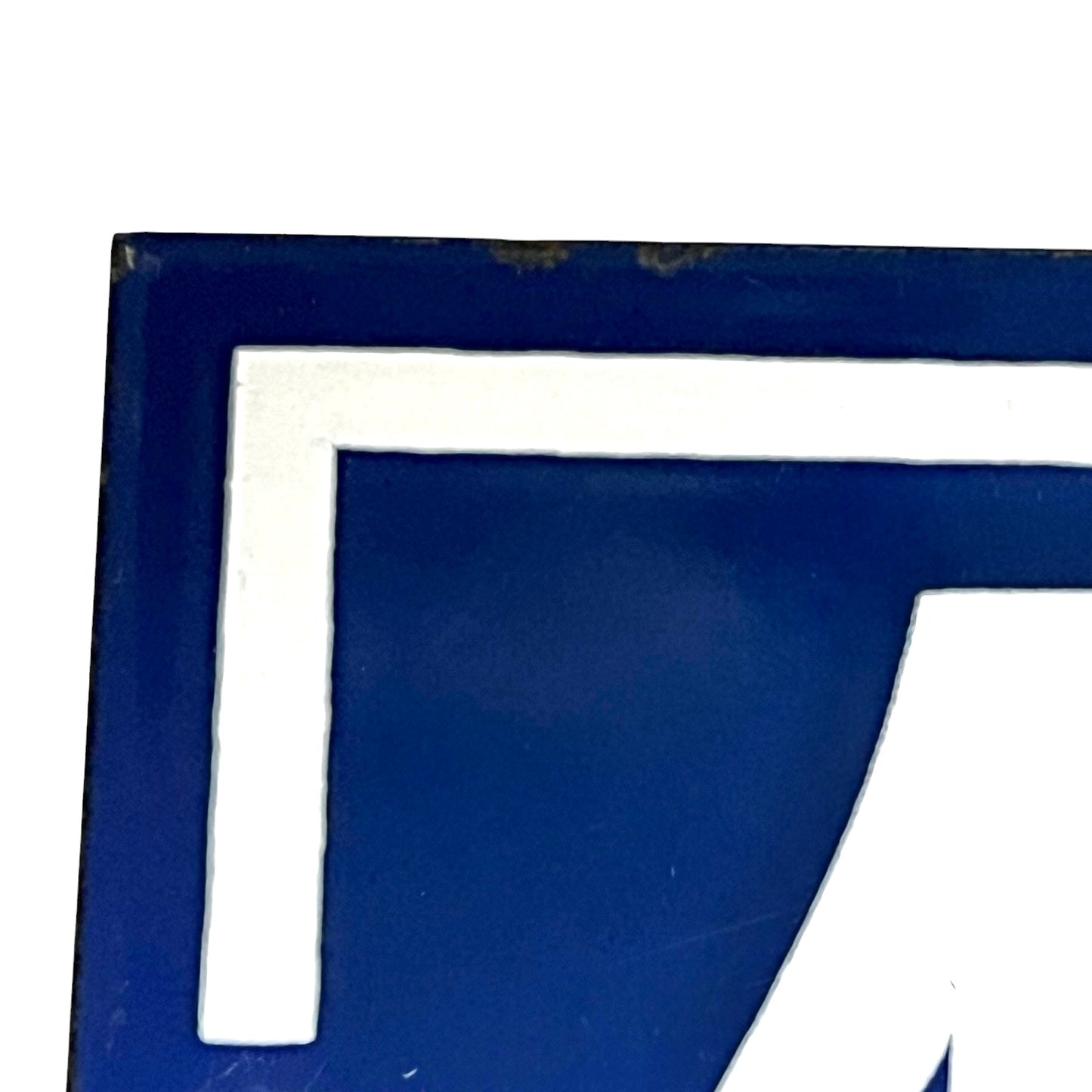 Close-up of a vintage French enamel door number on a white background.