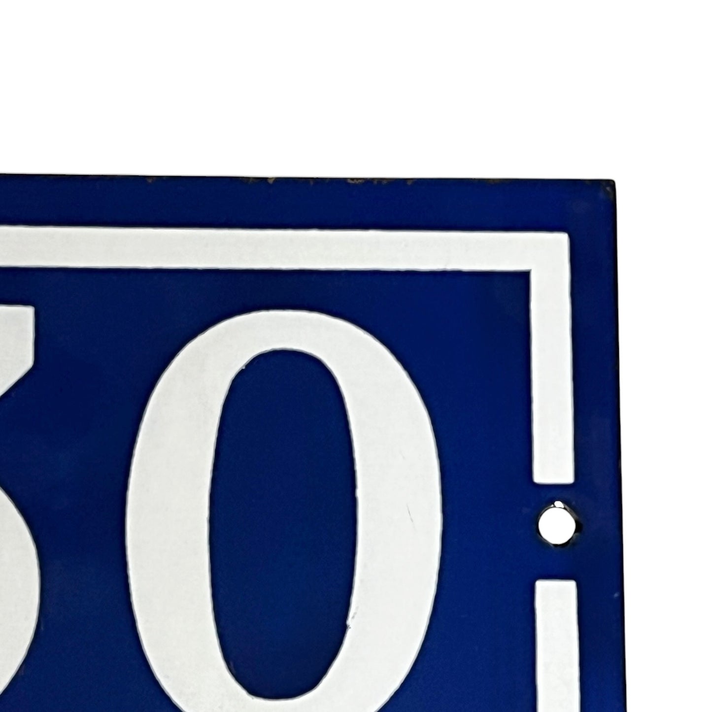 Close-up of a blue and white sign with the number '30'.