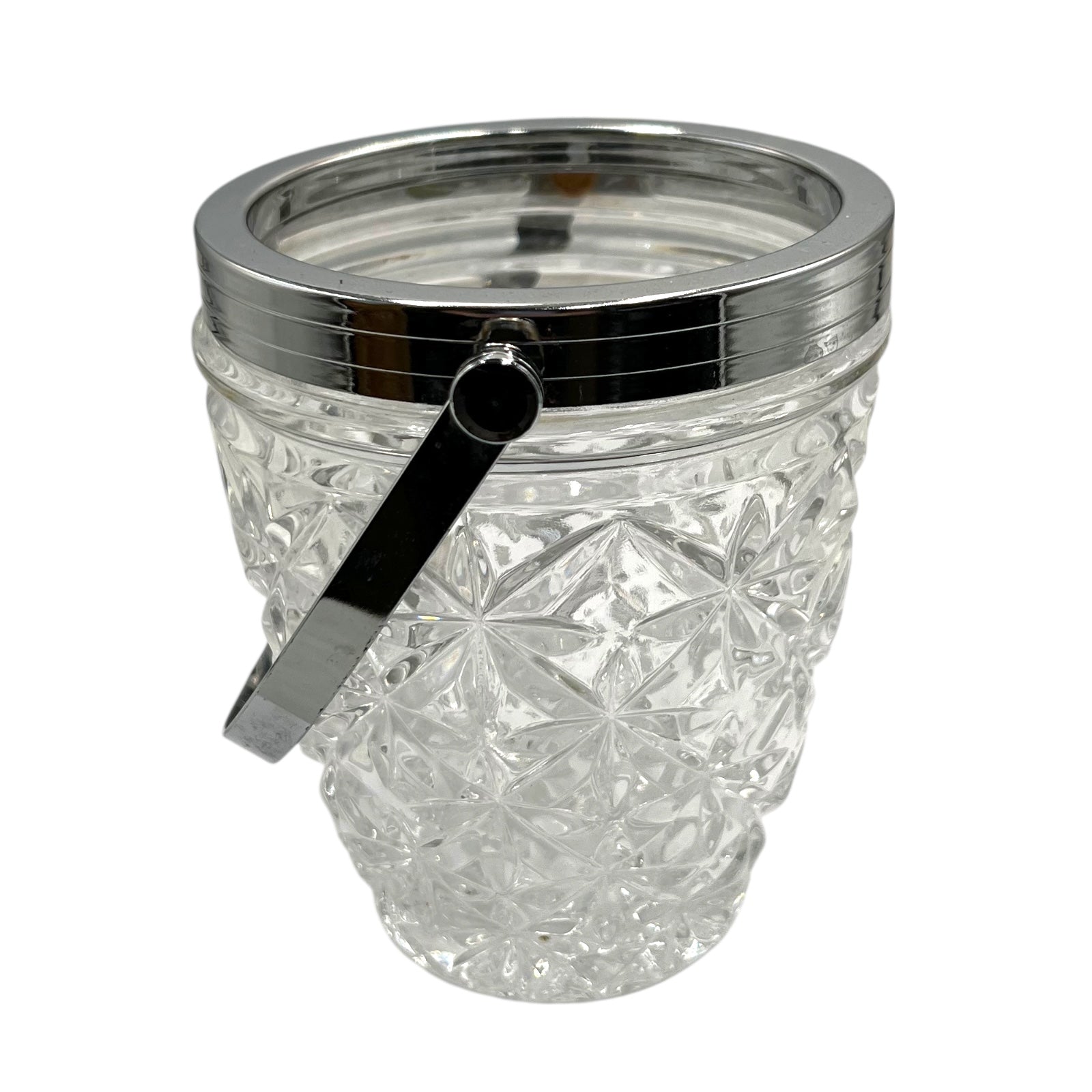 Clear French cut glass ice bucket with textured design and metal handle on a white background