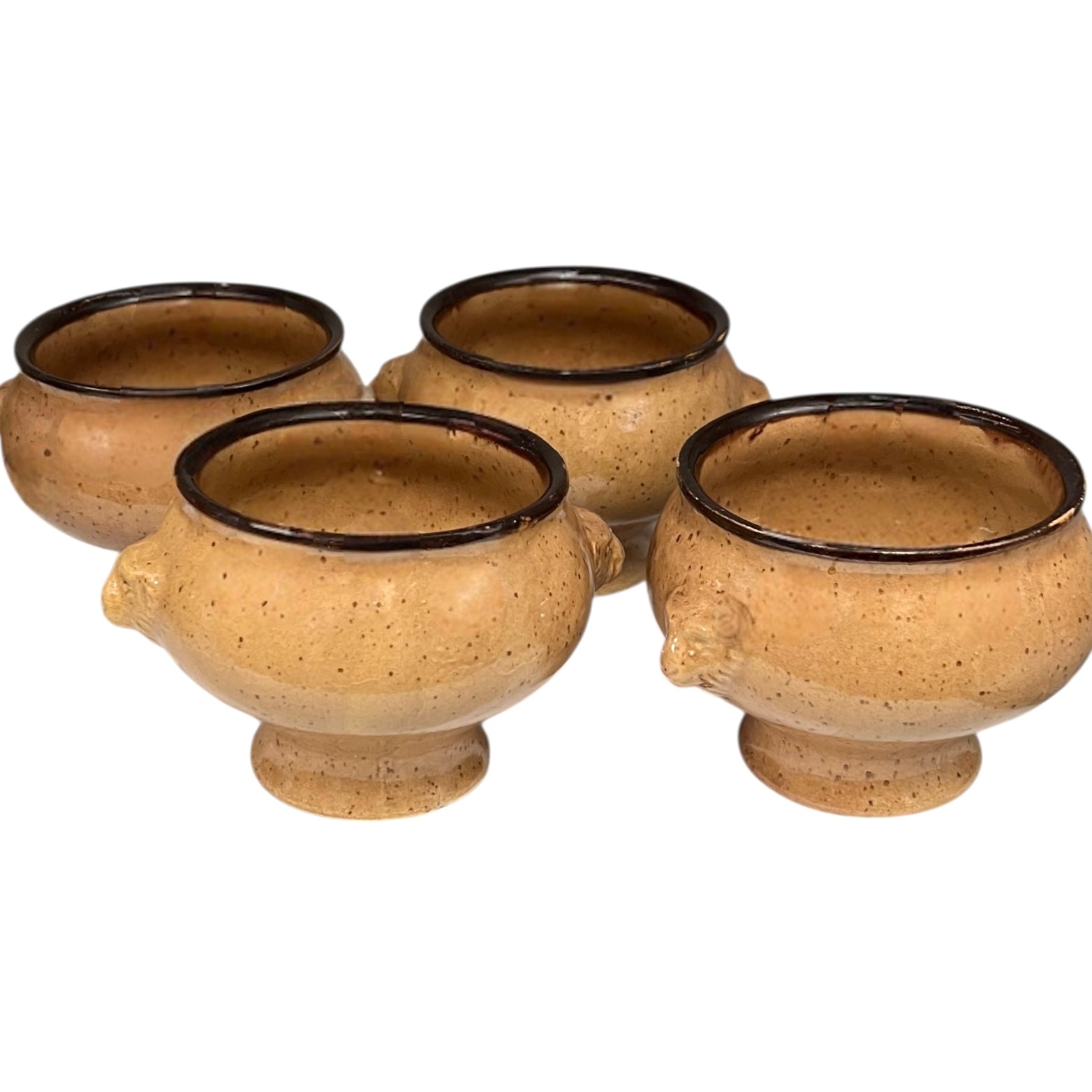 Set of four speckled beige lions head soup bowls with dark rims on a white background