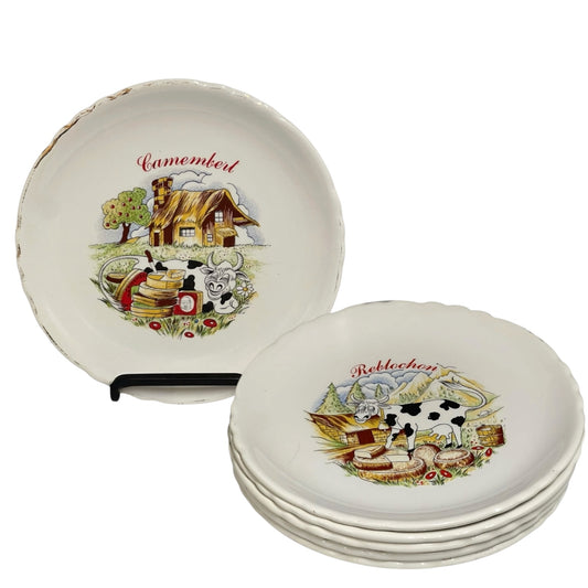 Set of ceramic cheese plates with farm-themed designs on a white background