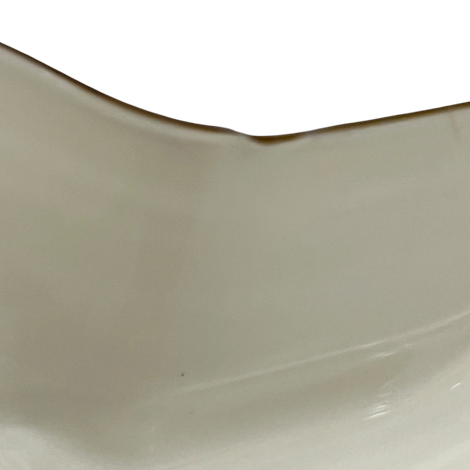 Close-up of a yellow glass shade showing a chip on a white background