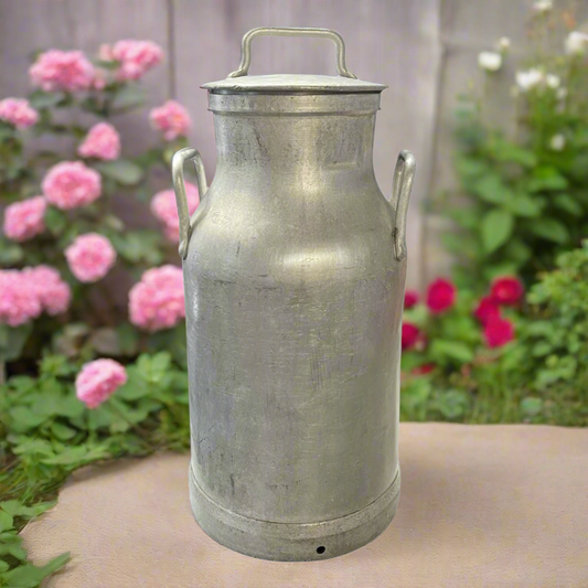 Close-up of a French metal vintage milk churn with a lid in a rustic garden setting