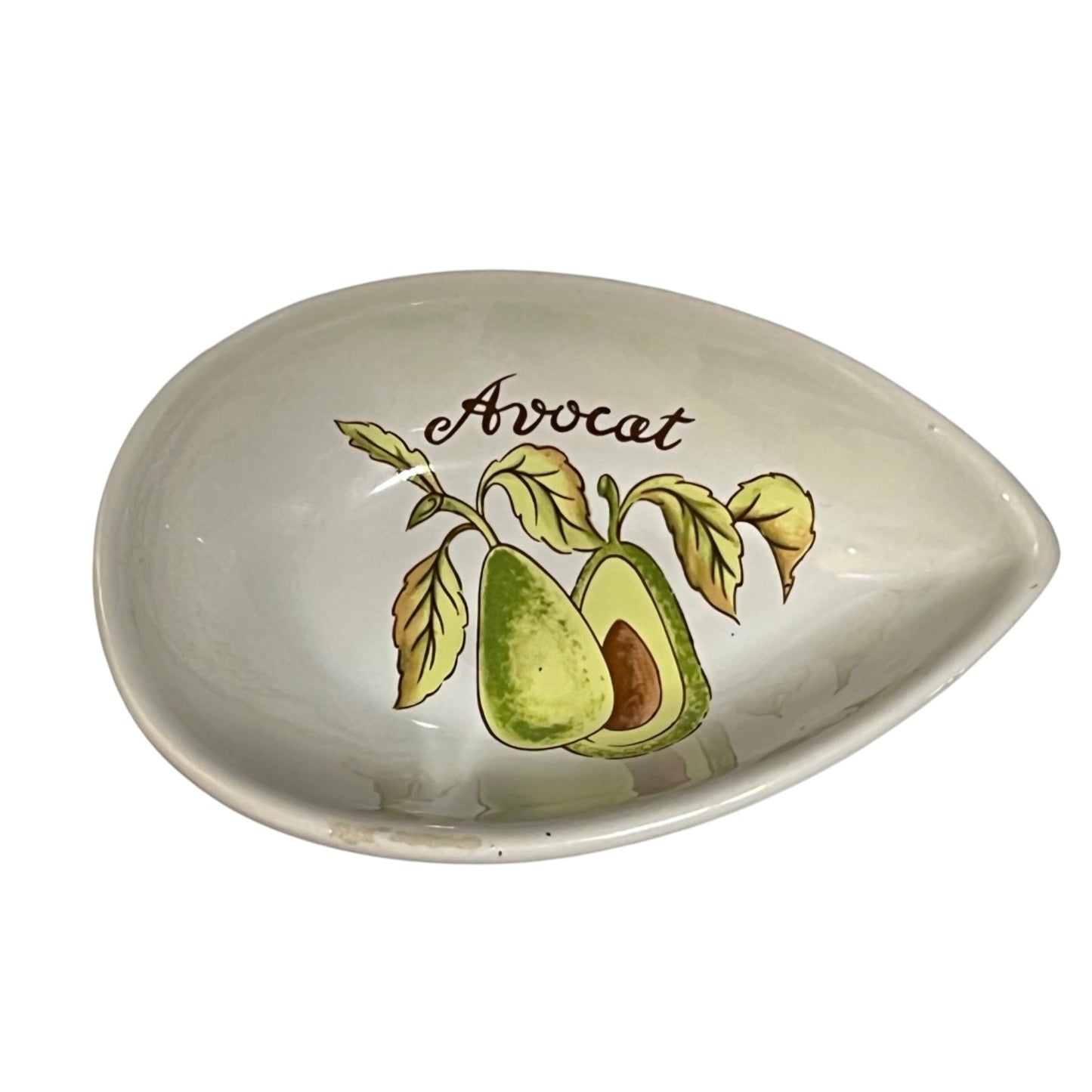 An oval ceramic dish with a teardrop-shaped pointed end, featuring a printed illustration of an avocado and the word 'Avocat' in brown script on a white background.