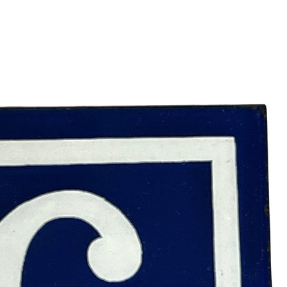 Close up of a French enamel door number on a white background 