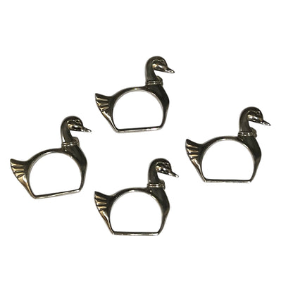 Four silver plated swan shaped napkin rings on a white background