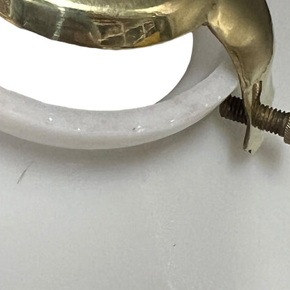 close up of white glass lampshade top opening with a brass clasp