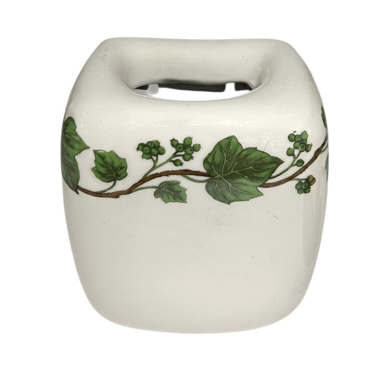 White ceramic toothbrush pot with green leaf design on a white background