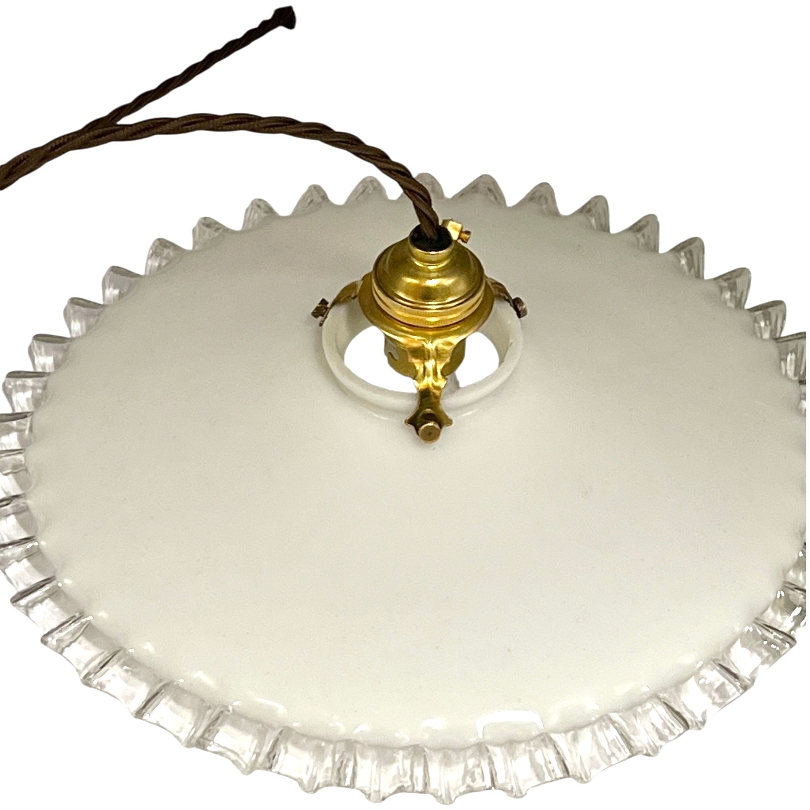 Close-up of a pendant light with white glass shade and brass fitting on a white background