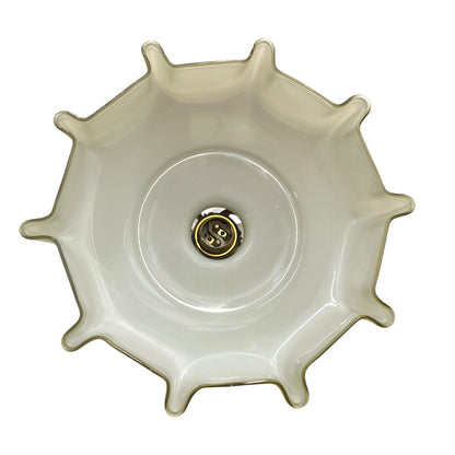 Close-up of a milk glass shade interior with a brass bulb holder on a white background