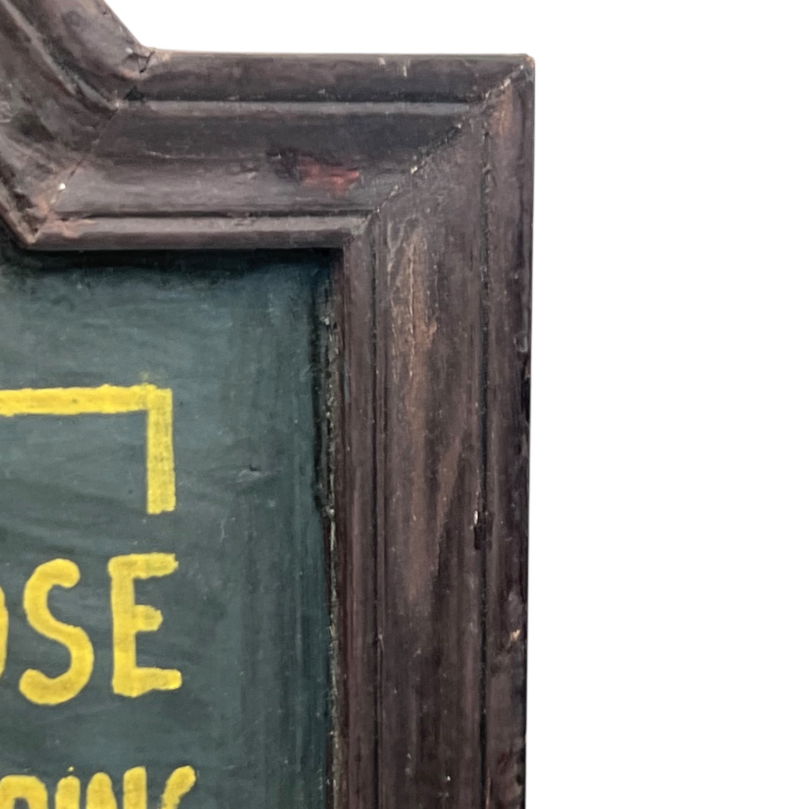 Corner of a framed picture with a dark brown frame and green interior.