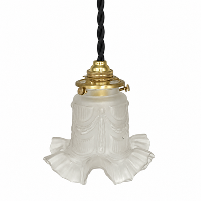 A vintage-style pendant light with a white ruffled glass shade, a brass metal top, and a black twisted cord, shown against a plain white background.