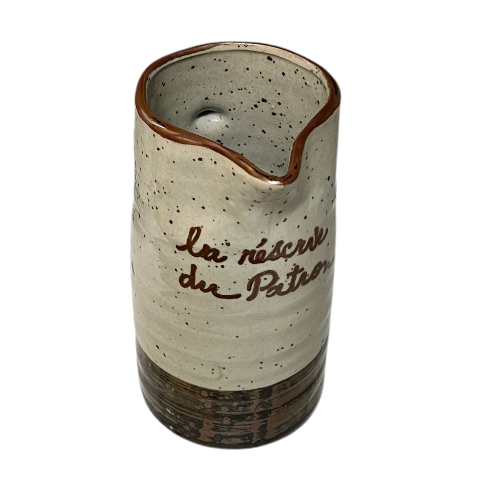 Ceramic speckled brown and cream vase with French text on a white background