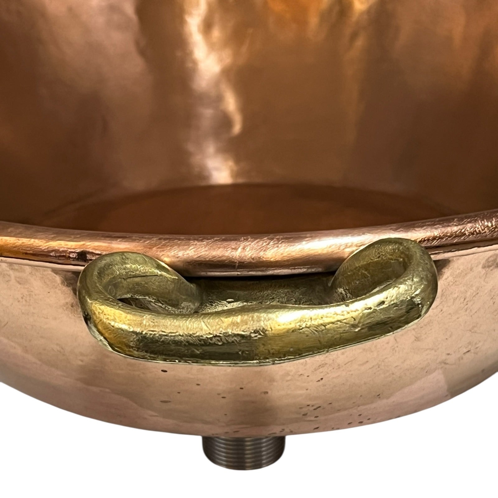 Close-up of a copper pot with a brass handle on a white background