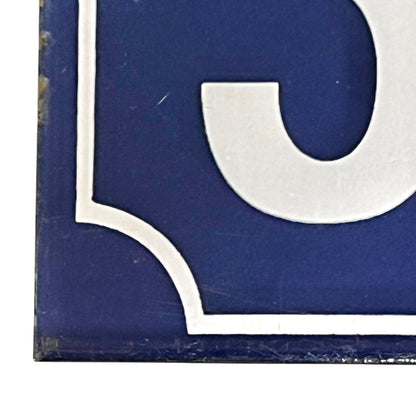 Close up of a French enamel door number 32 on a white background 