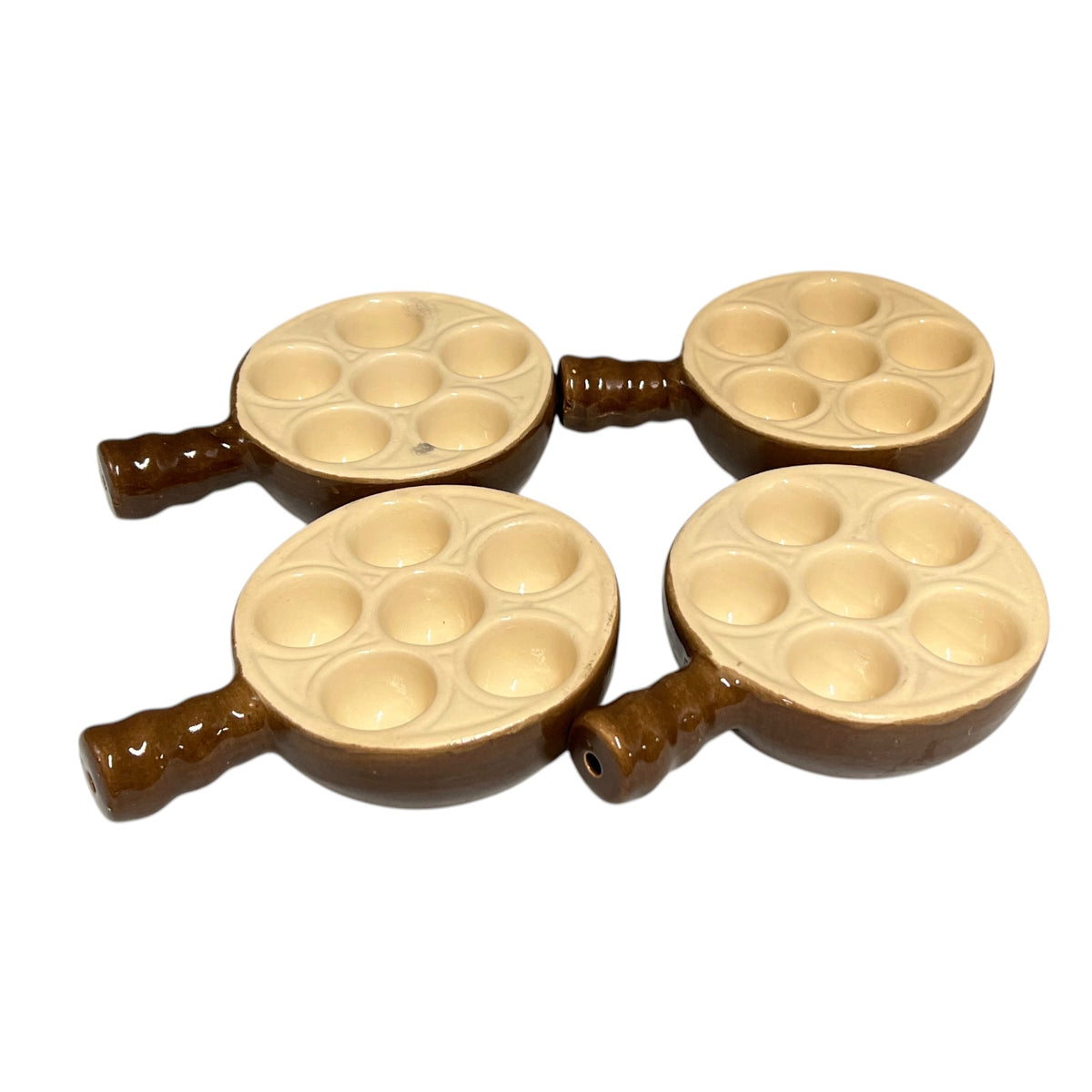 Four small brown and beige ceramic escargot dishes arranged in a 2x2 grid on a plain white background.