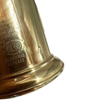 Close-up of a gold object with engraved text on a white background
