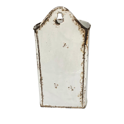 A vintage-style metal wall hook with a distressed white enamel finish and dark brown rust-like detailing around the edges and top loop.