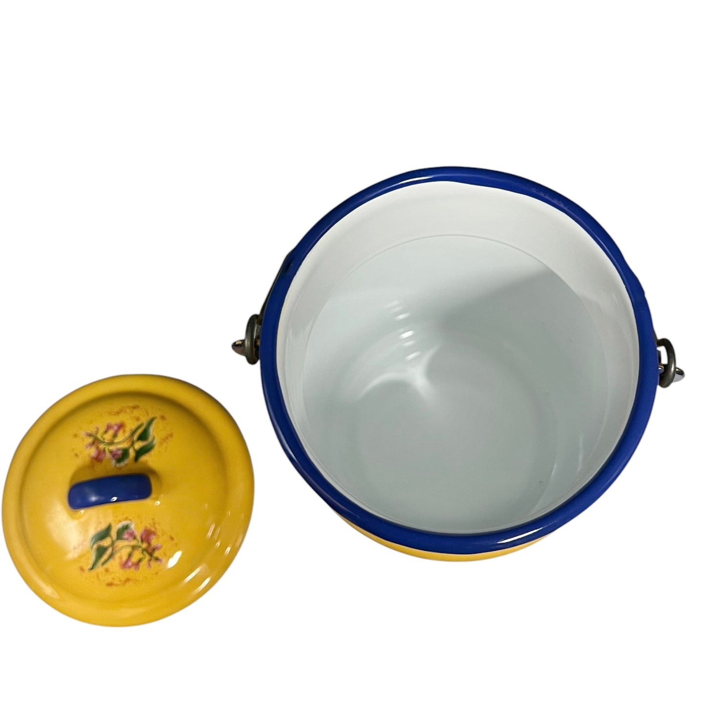 A yellow enamel storage container with a blue rim and floral decoration on the lid, shown open with the lid placed beside it on a white background.