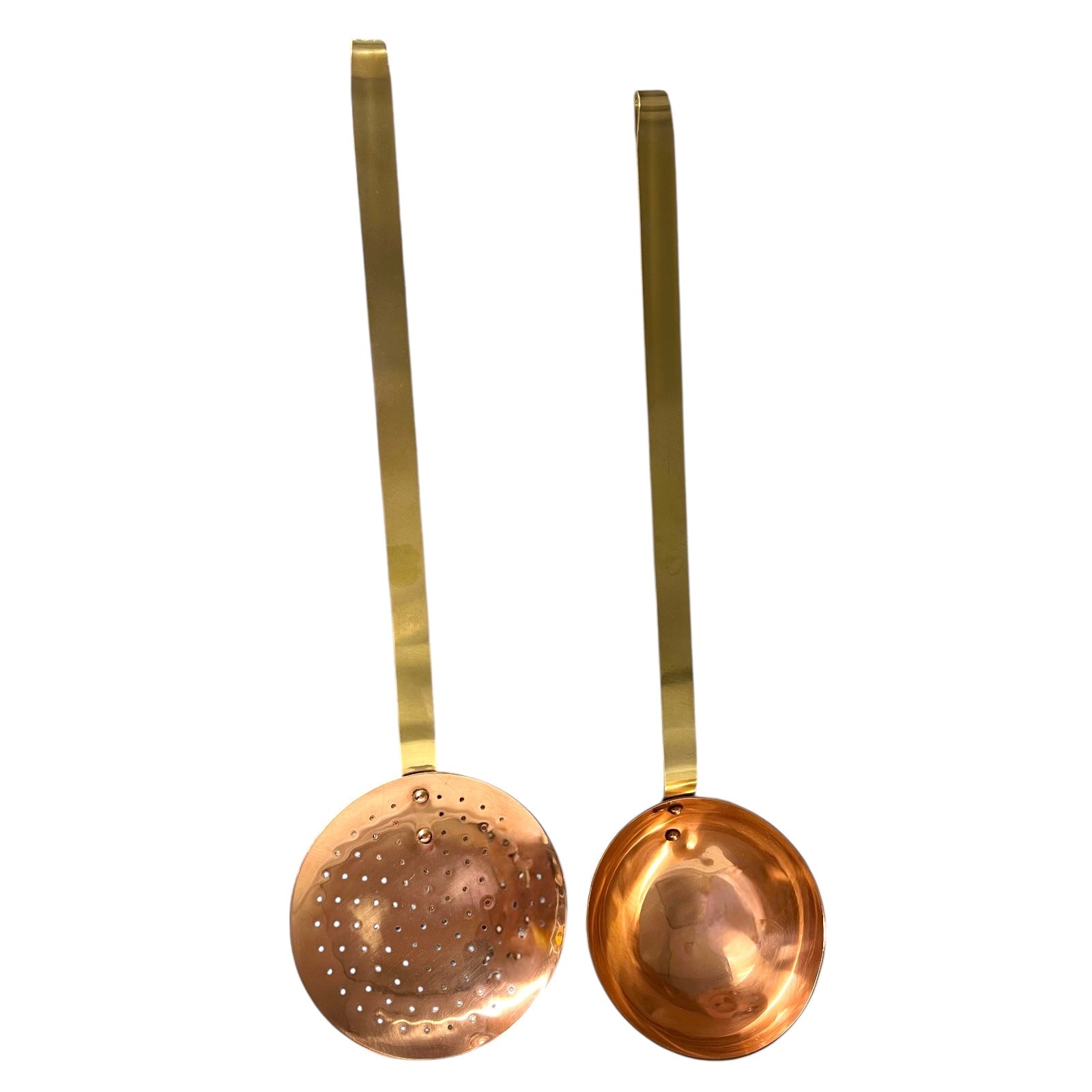 Set of 2 French copper utensils with long brass handles, includes a straining spoon and a ladle on a white background