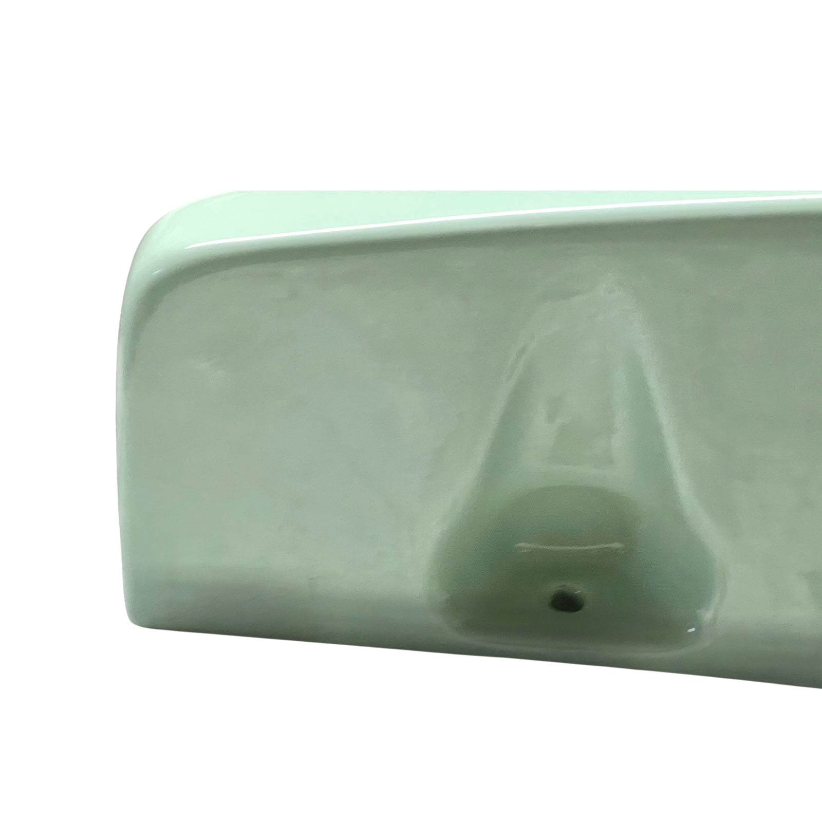 close up of pale green ceramic shelf on a white background