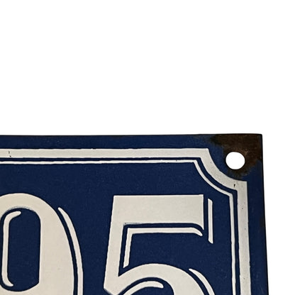 Close-up of a blue and white house number plate with '05'.