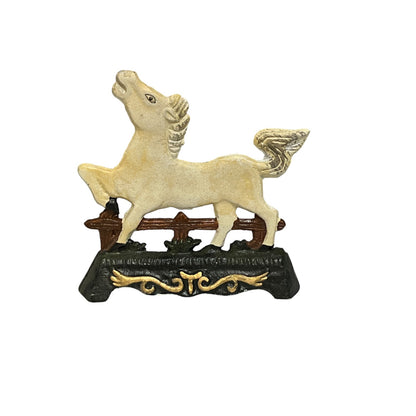 A decorative horse dootstop standing on a dark base with gold scrollwork, isolated on a white background