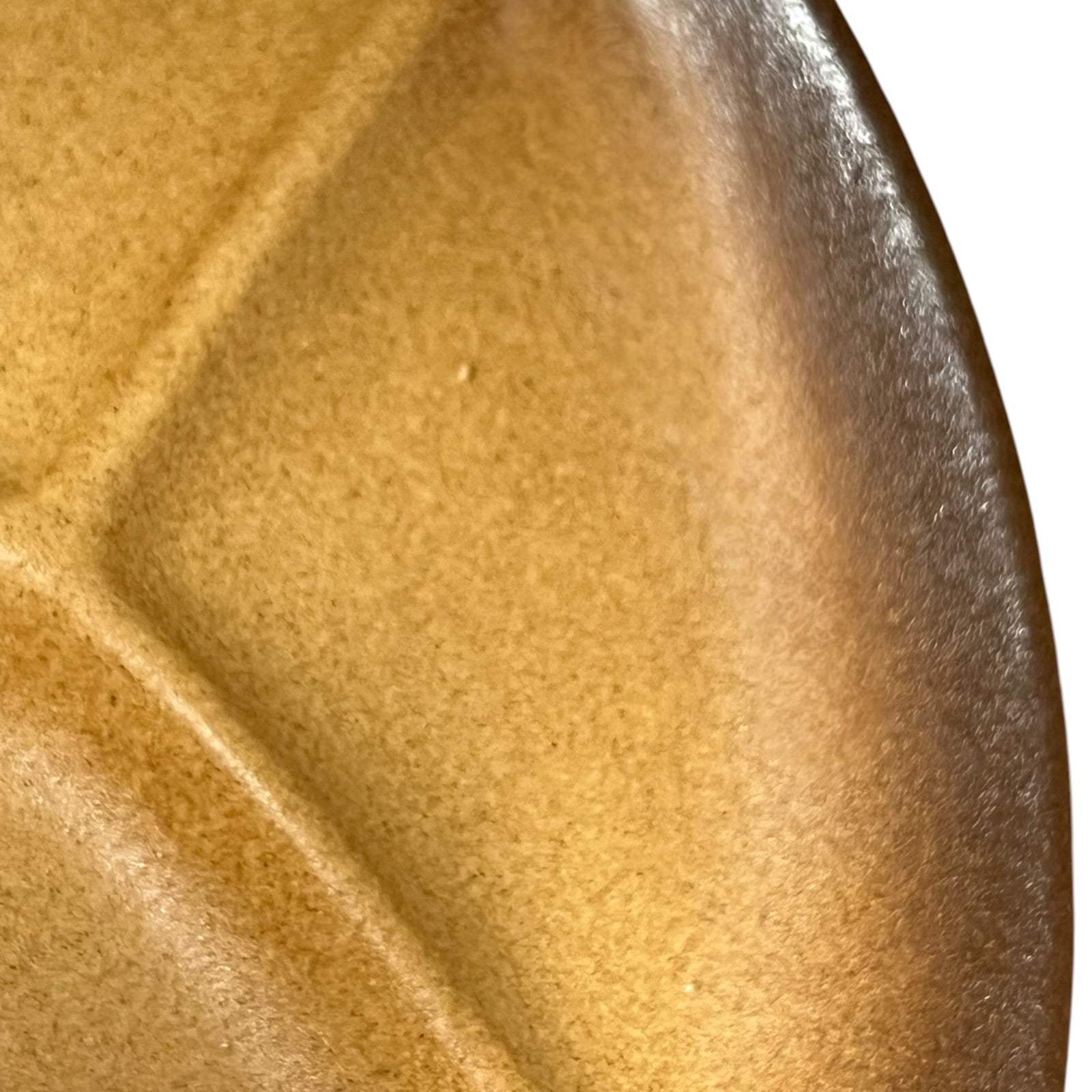Close-up of a textured brown plate on a white background