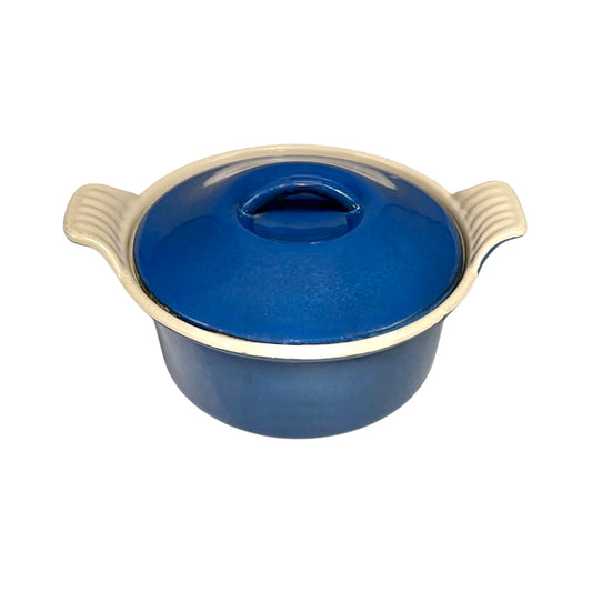 Small blue ceramic pot  by Le Creuset on a white background