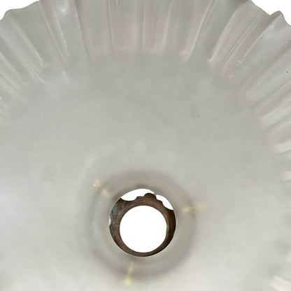 Close-up of a glass lamp shade with a scalloped edge on a white background