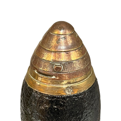 Close up of a British WW1 brass fuse on a black shrapnel shell st on a white background 