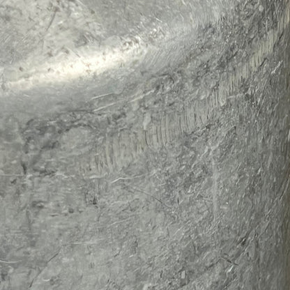 close up of metal milk churn on a white background