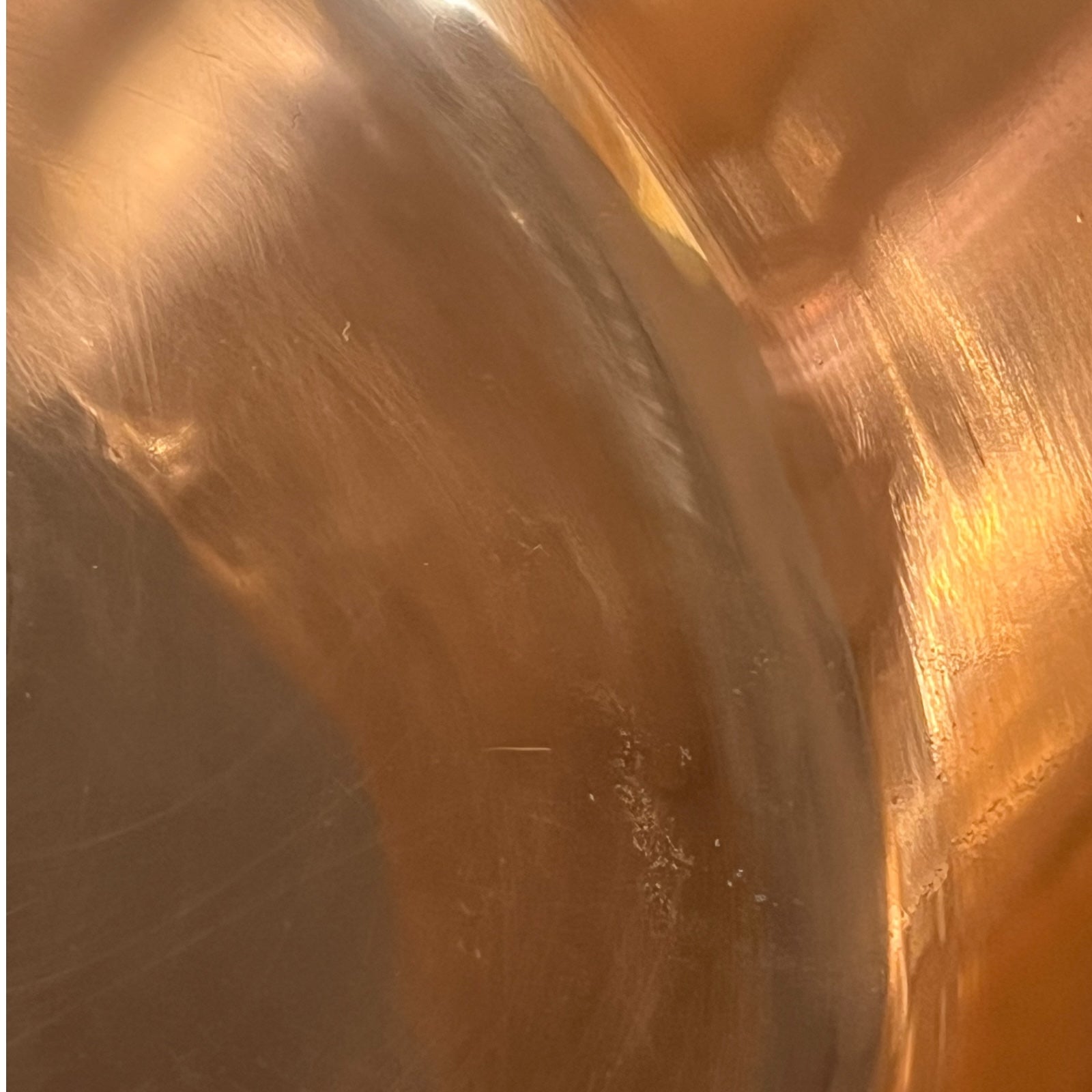 Close-up of a copper sink with a brass handle on a white background