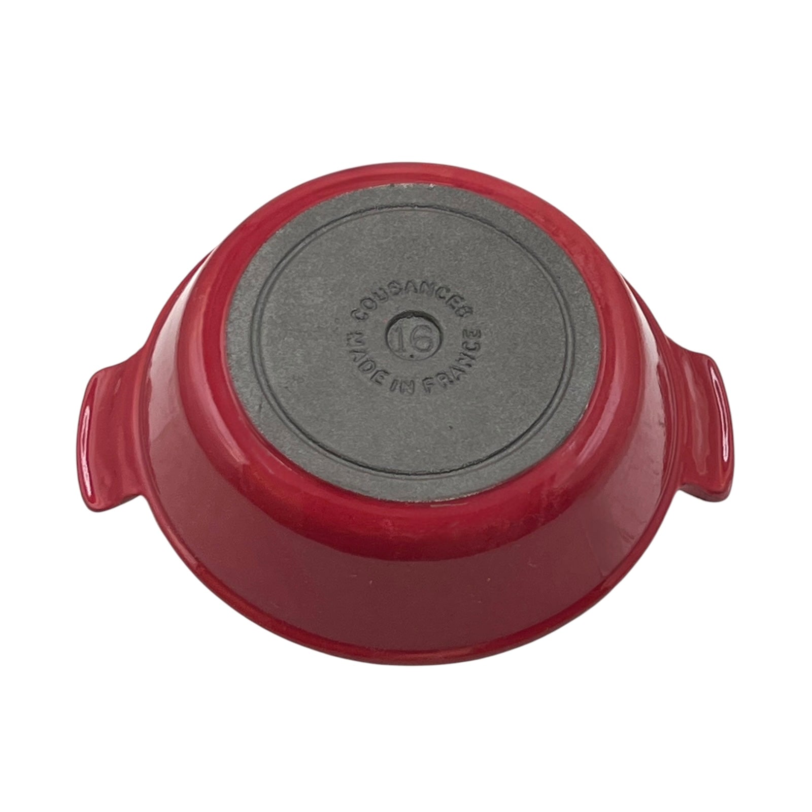 A red enameled cast iron casserole dish shown from its bottom side, displaying a dark gray non-stick coating and embossed 'Cousances' branding, on a solid white background.