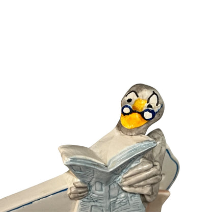 Decorative novelty door sign for a toilet labelled in French as Toilettes, with a goose reading a newspaper  decoration on a white background