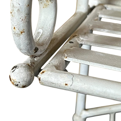 Close-up of a white metal shelf with visible wear and tear on a white background
