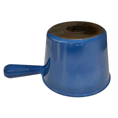 close up of blue cast iron pan with beige interior on a white background
