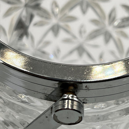 Close up of French cut glass ice bucket with textured design and metal handle on a white background 