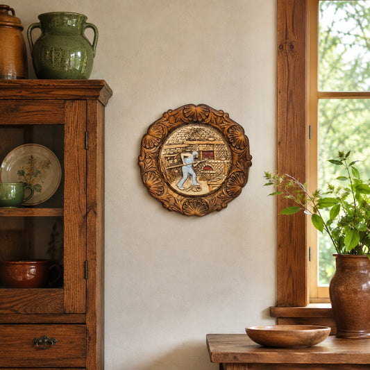 French vintage circular raised 3d wood resin wall plaque on a wall in a rustic kitchen with a wooden cabinet and a vase with greenery