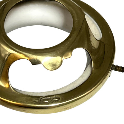 A close-up of a circular brass lampshade component with a threaded screw visible on the right side, photographed against a plain white background.