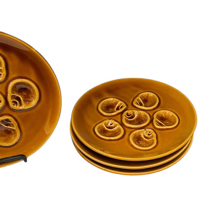 Set of brown ceramic plates with embossed designs on a white background
