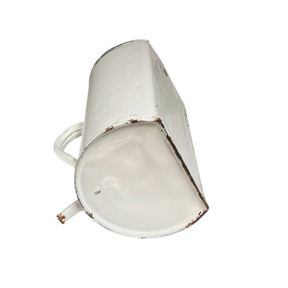 A vintage white enamel metal cup with a distressed finish showing brown rusted edges, isolated on a white background.